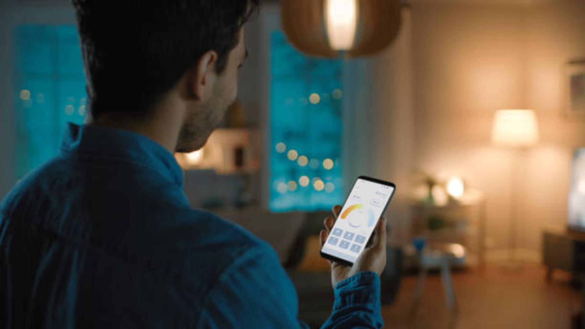 A person using a smartphone to control the lighting in their smart home.
